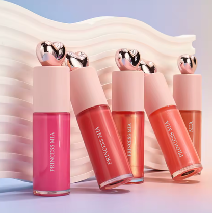 Set of Princess MIA lip glosses with pink and red shades on a soft fabric background