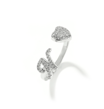 Silver open ring with heart-shaped top and curved design on a white background