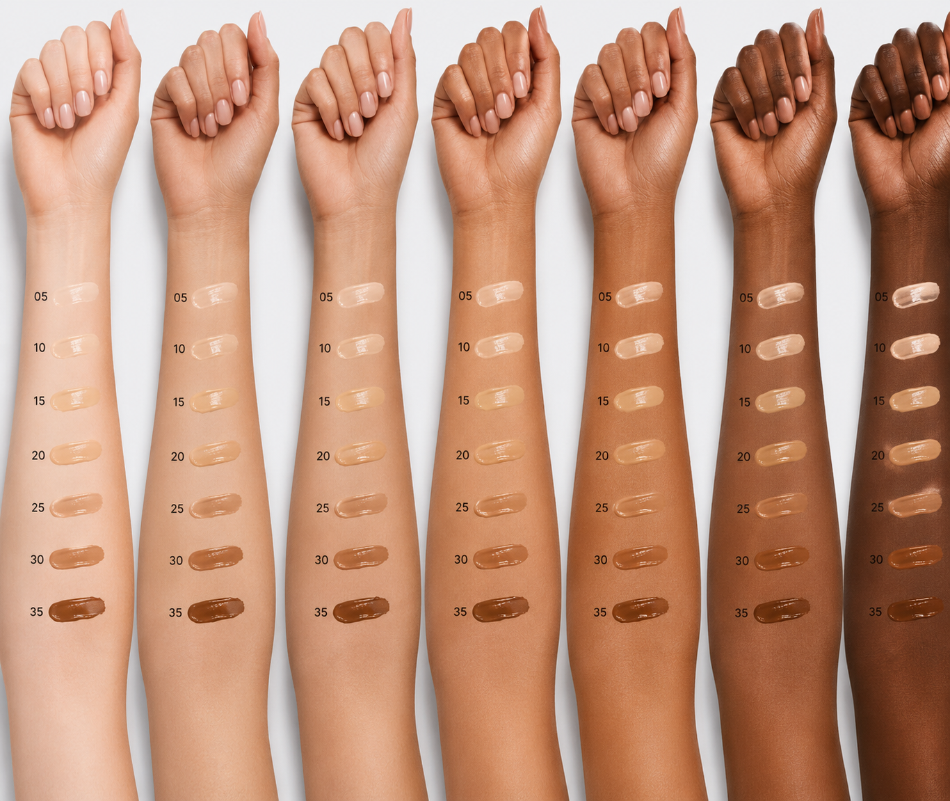 Row of arms with different skin tones displaying makeup swatches on a white background