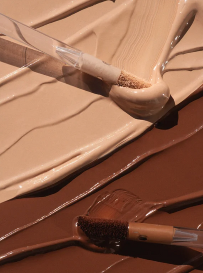 Close-up of a makeup palette with beige and brown shades and brushes.